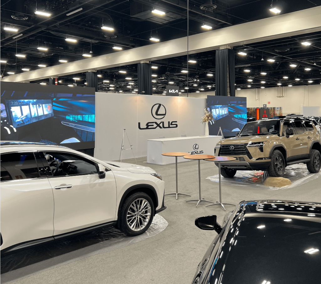 Lexus booth at a car exhibition showcasing different models with large LED screens displaying promotional videos.