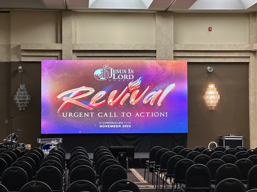 Indoor event setup with a large LED screen displaying a religious conference message, perfect for conferences and gatherings.